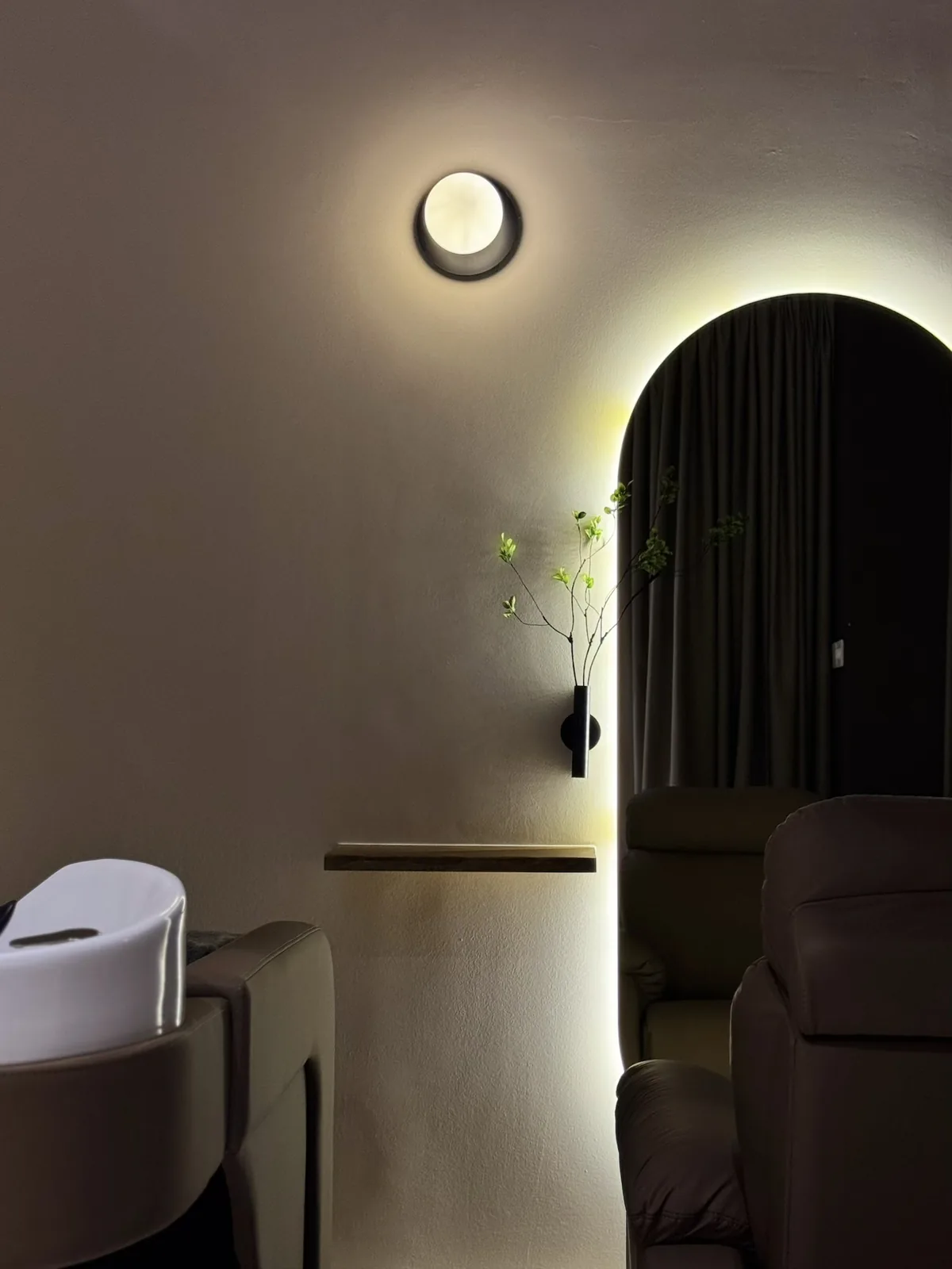 The Haru treatment room in Johor Bahru, with reclining treatment chairs, a scalp-washing basin and a softly lit arched alcove